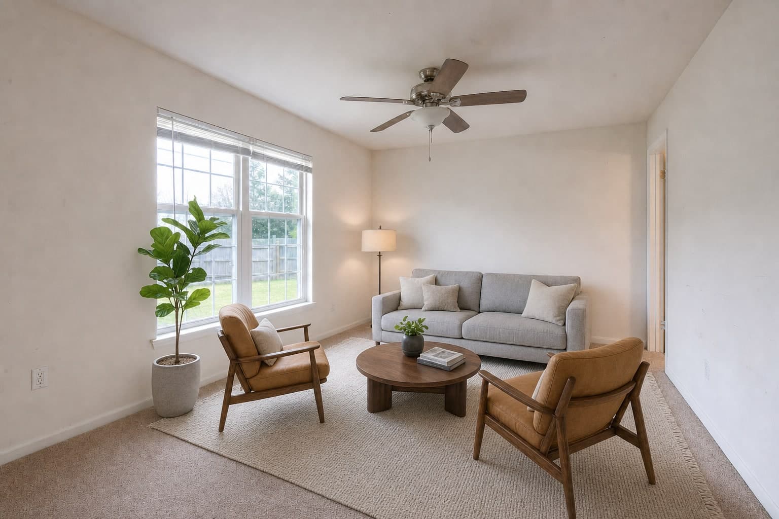 A living room from the entry corner, empty and then staged, finished