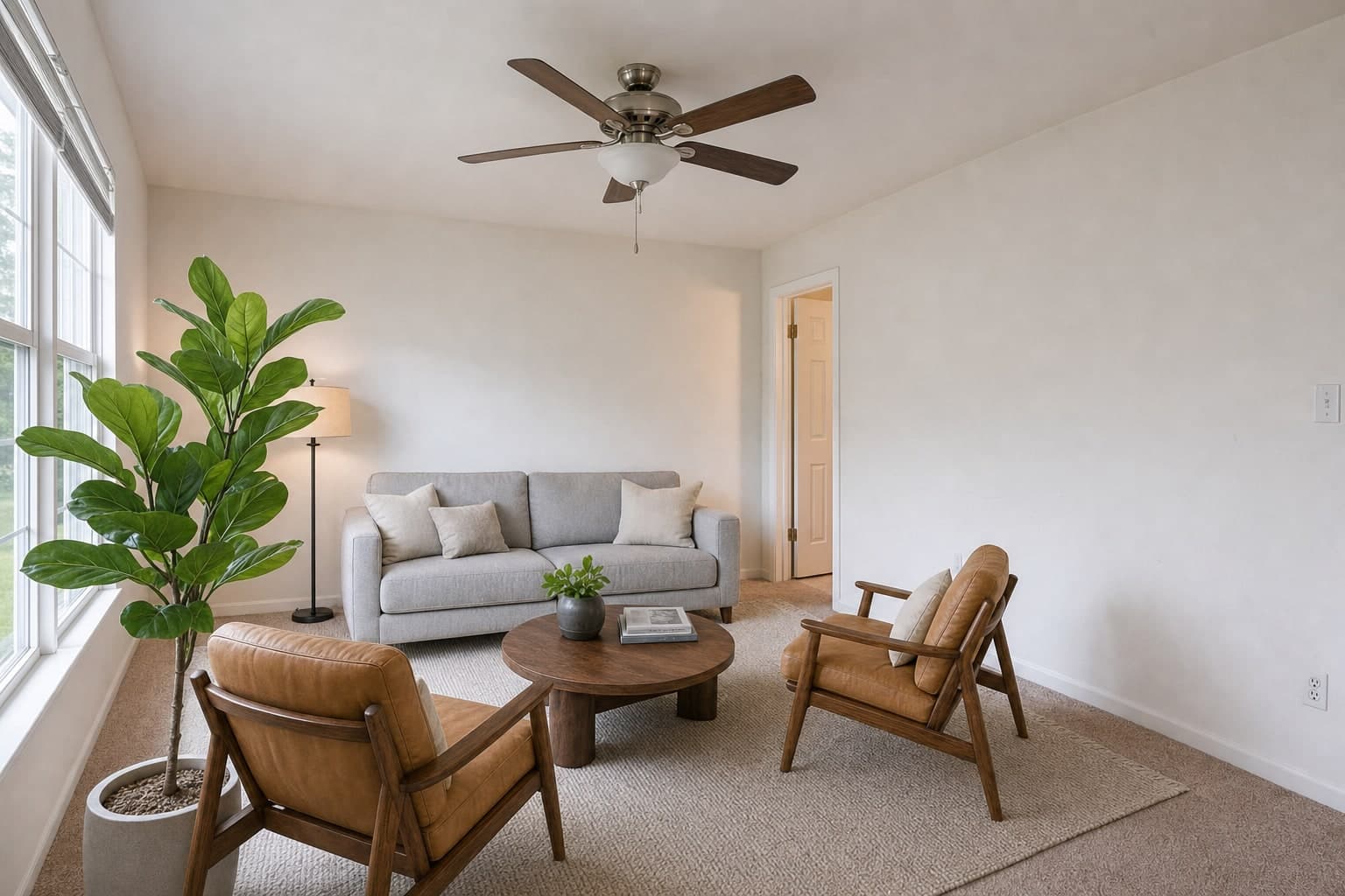 The same living room from beside the window, empty and then staged with the same furniture, finished